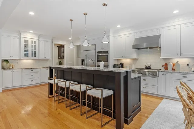 a kitchen with kitchen island granite countertop a sink a counter space appliances and cabinets