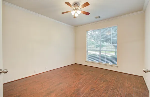 an empty room with a window and a ceiling fan