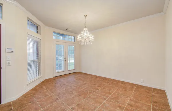 en empty room with windows and chandelier
