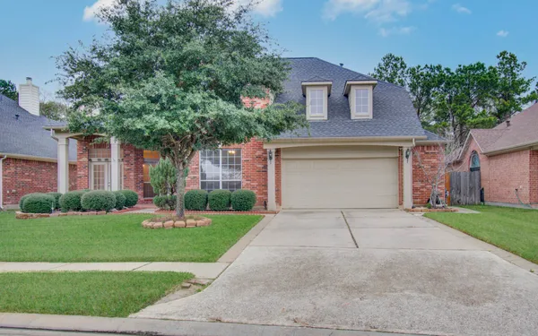 a front view of a house with a yard and a garage