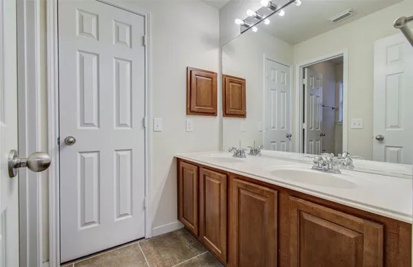 a bathroom with a double vanity sink and a mirror