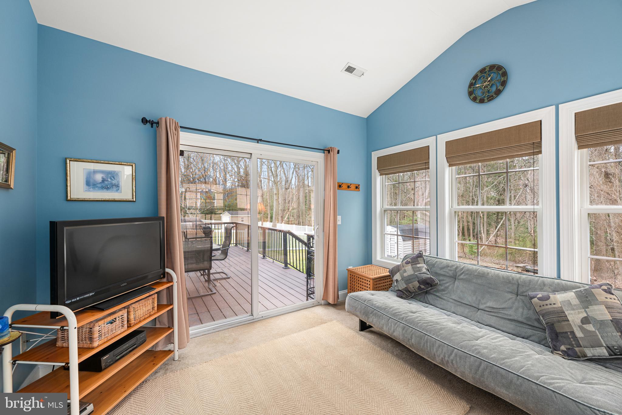 27400 Walking Run Milton, DE 19968 - Photo 17 of 35 a living room with furniture a flat screen tv and floor to ceiling window