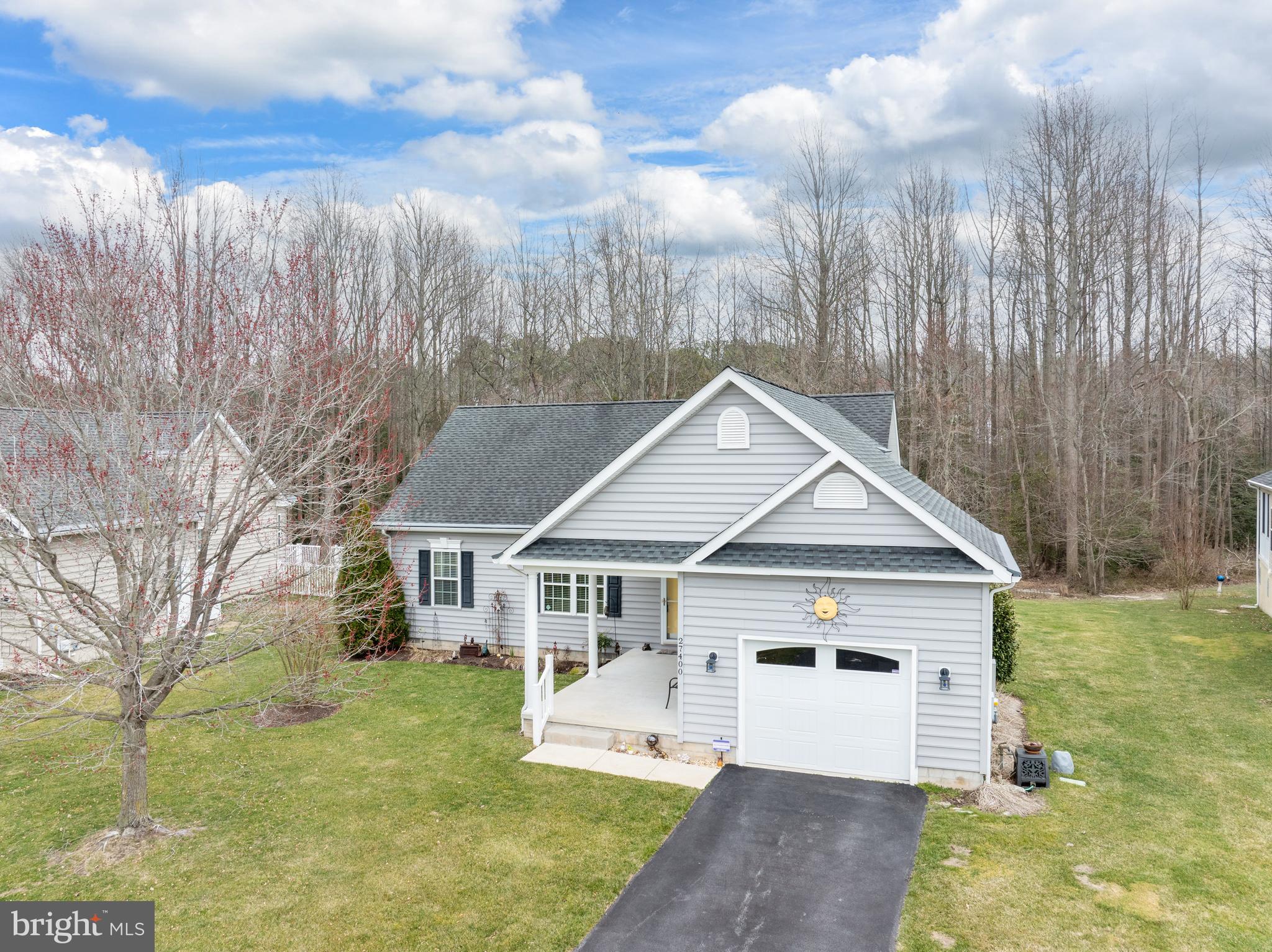 27400 Walking Run Milton, DE 19968 - Photo 31 of 35 a view of a white house next to a yard with big trees