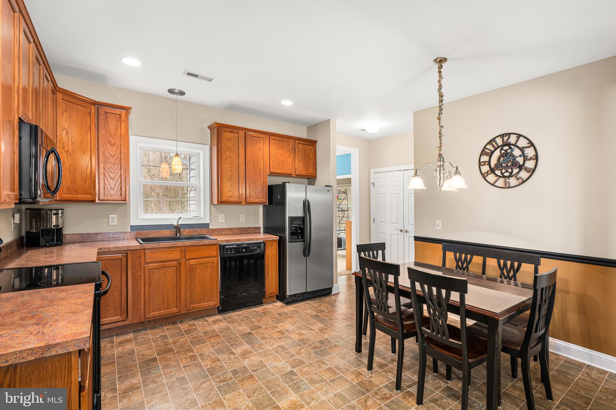 27400 Walking Run Milton, DE 19968 - Photo 6 of 35 a kitchen with stainless steel appliances granite countertop a stove a refrigerator a kitchen island a dining table and chairs with wooden floor