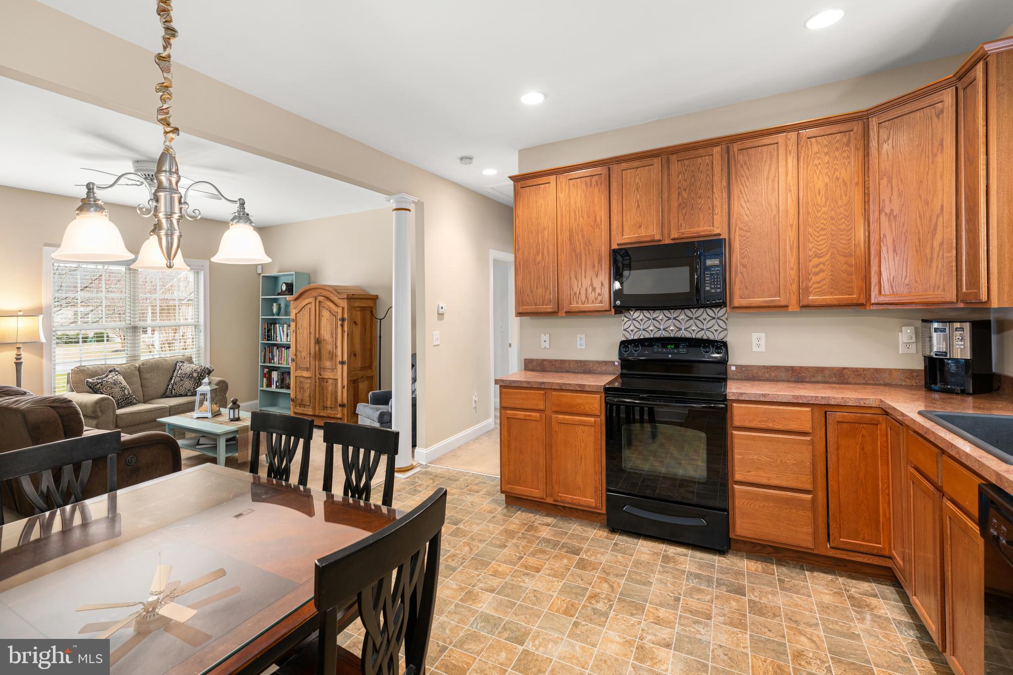 27400 Walking Run Milton, DE 19968 - Photo 7 of 35 a kitchen with stainless steel appliances granite countertop a stove a sink dishwasher a dining table and chairs with wooden floor