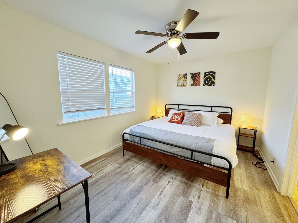 2405 Teri Road Austin, TX 78744 - Photo 15 of 18 a bedroom with a bed and wooden floor