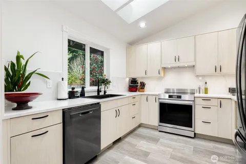 a kitchen with a white stove top oven and white cabinets