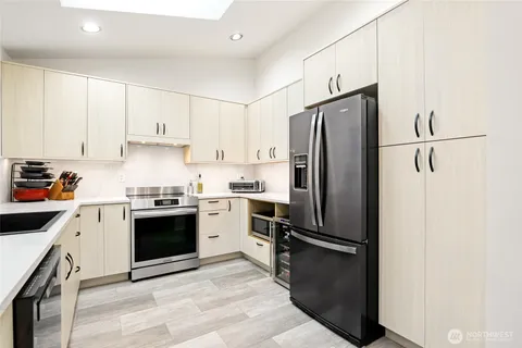 a kitchen with granite countertop a refrigerator stove and sink