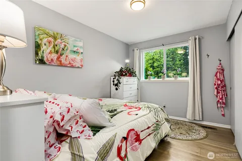 a bedroom with a bed and a painting on the wall