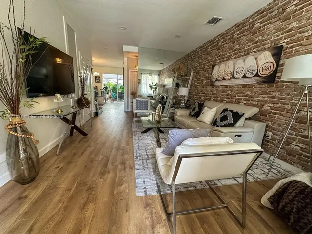 a living room with patio furniture and a flat screen tv