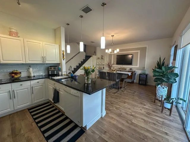 a kitchen with a sink cabinets and wooden floor