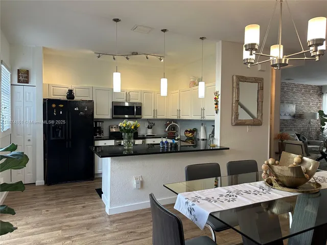a kitchen with a table chairs refrigerator and microwave