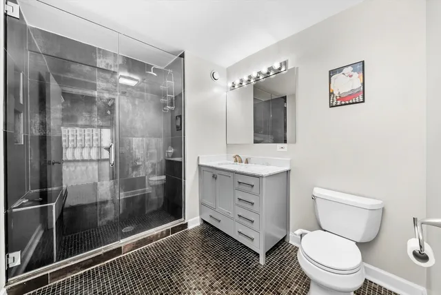 a bathroom with a toilet a sink and glass door shower