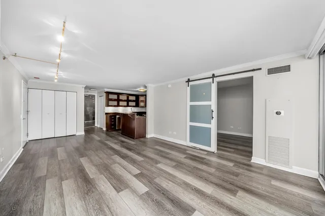 an empty room with wooden floor fireplace and windows