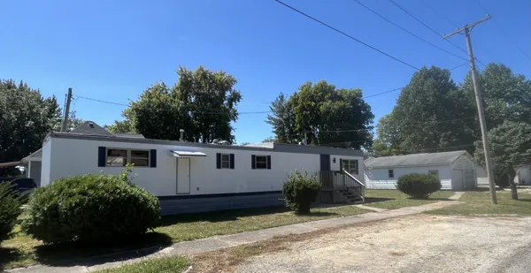 a view of a house with backyard and sitting area