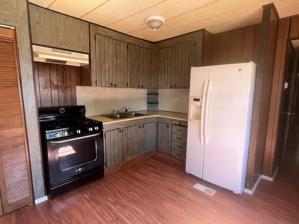 a kitchen with a stove a refrigerator and a sink
