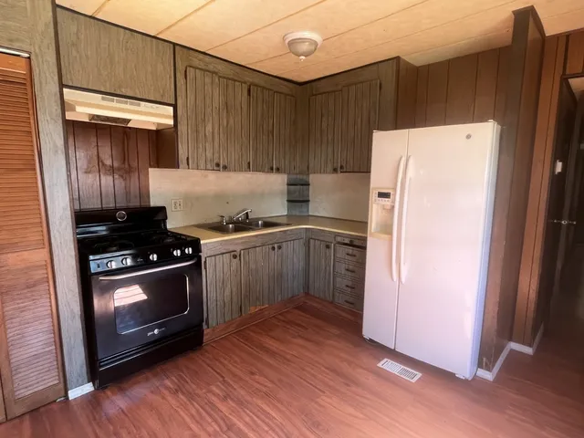 a kitchen with a stove a refrigerator and a sink