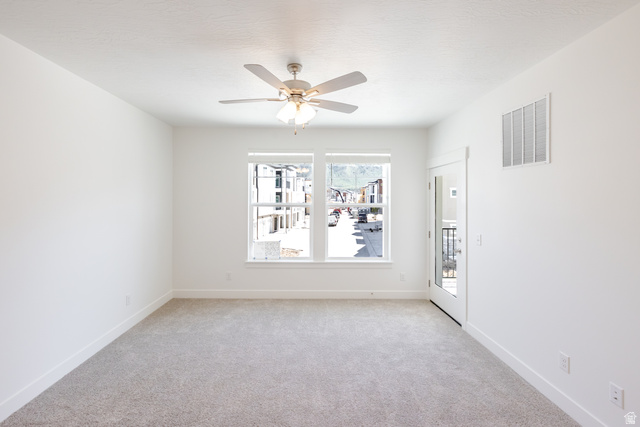 675 West 4500th South, Unit P204 Mapleton, UT 84664 - Photo 15 of 16 Carpeted room featuring a ceiling fan with light, two casement windows, a white door with glass panel, and a wall-mounted vent