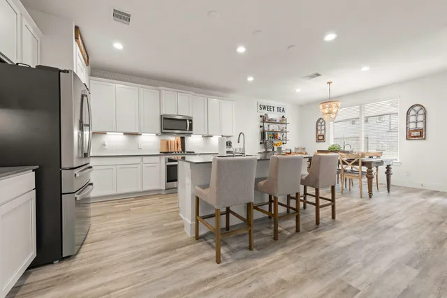 a kitchen with a table chairs refrigerator and cabinets