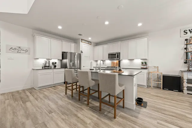 a kitchen with white cabinets and stainless steel appliances