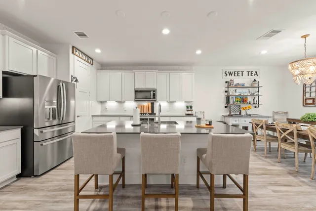 a kitchen with granite countertop cabinets stainless steel appliances a sink and wooden floor