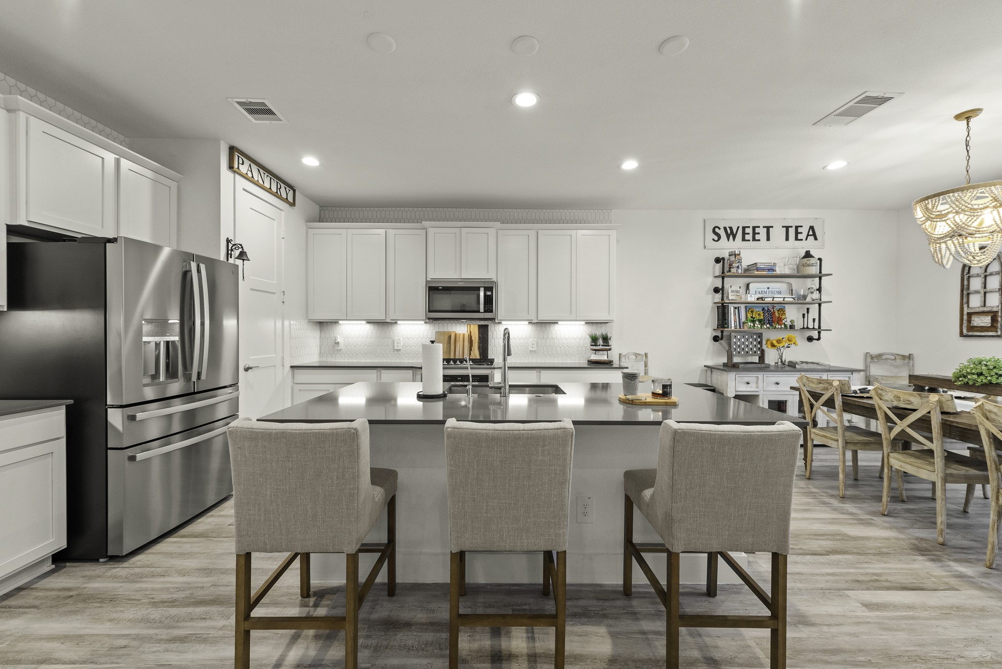 10009 Gray Jay Court Conroe, TX 77384 - Photo 14 of 47 a kitchen with a dining table chairs refrigerator and cabinets