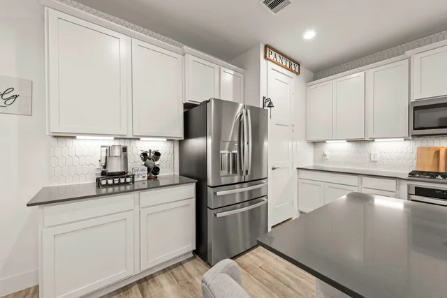 a kitchen with lots of counter space a sink appliances and cabinets