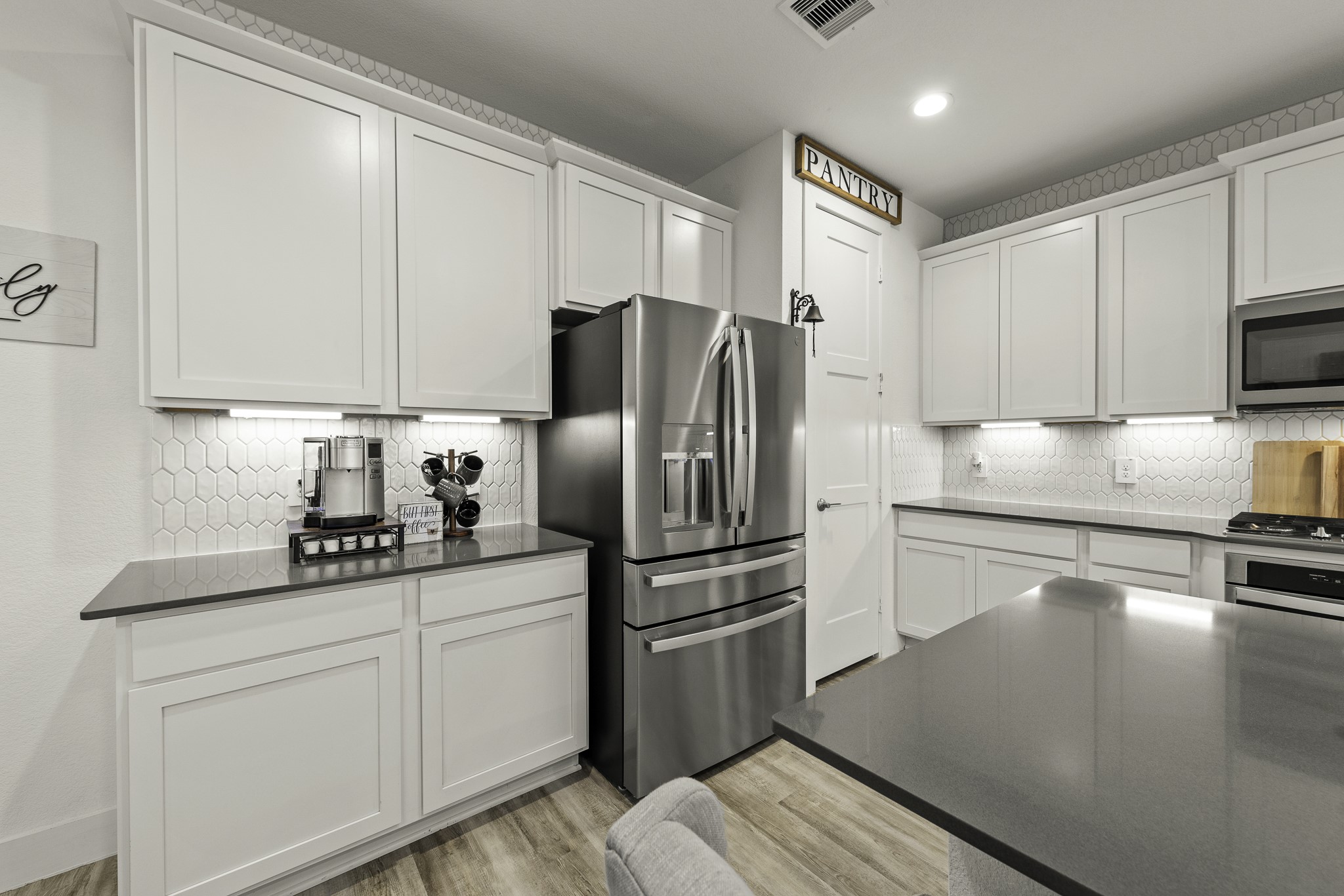 10009 Gray Jay Court Conroe, TX 77384 - Photo 15 of 47 a kitchen with white cabinets and stainless steel appliances