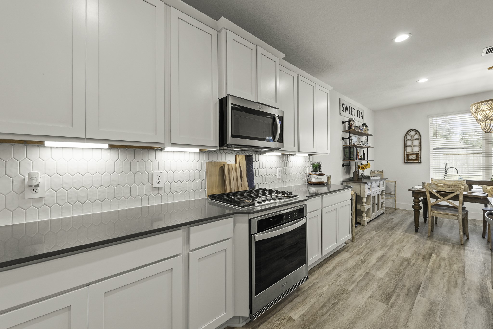 10009 Gray Jay Court Conroe, TX 77384 - Photo 16 of 47 a kitchen with granite countertop cabinets stainless steel appliances a sink and wooden floor