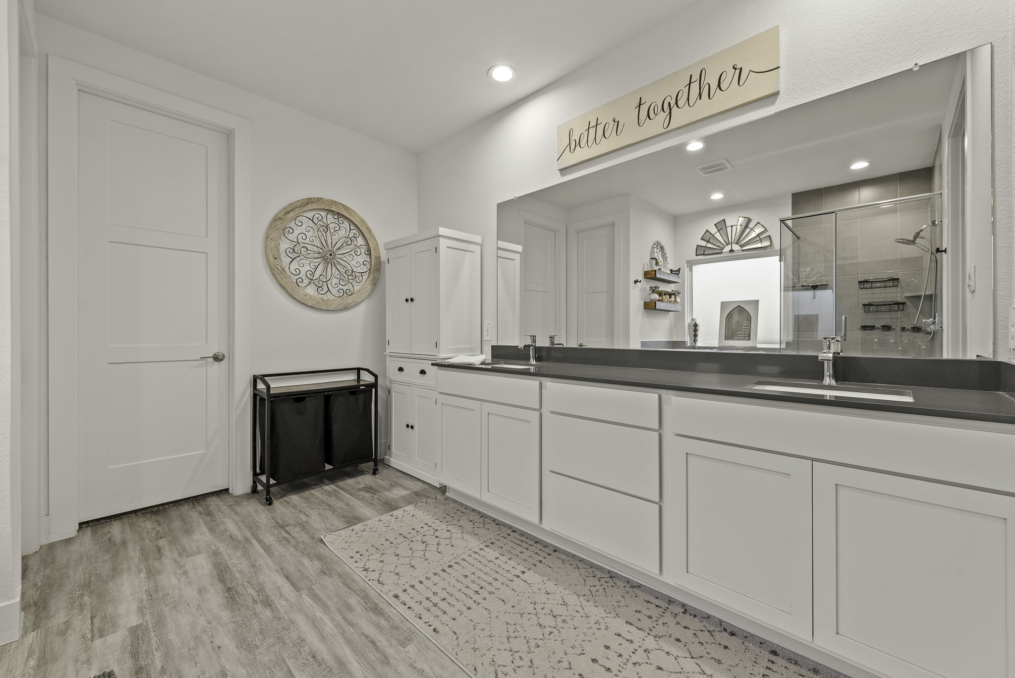 10009 Gray Jay Court Conroe, TX 77384 - Photo 22 of 47 a spacious bathroom with a sink a mirror and a clock on the wall