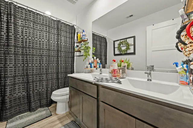 a bed room with a bed a computer on a desk and a television