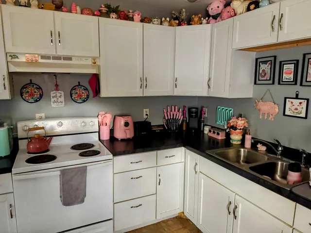 a kitchen with white cabinets and white appliances