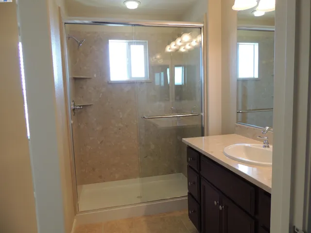 a bathroom with a granite countertop sink a toilet and shower