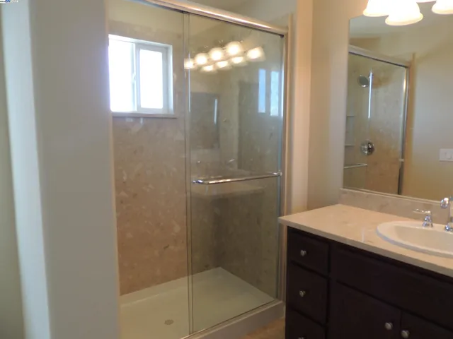 a bathroom with a sink mirror and a shower