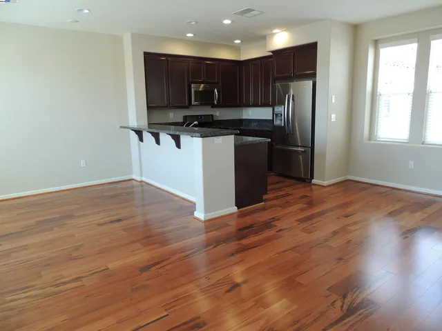 a kitchen with stainless steel appliances granite countertop a refrigerator microwave and stove