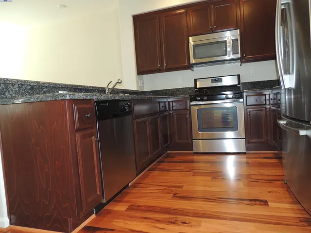 a kitchen with stainless steel appliances wooden cabinets and a stove top oven