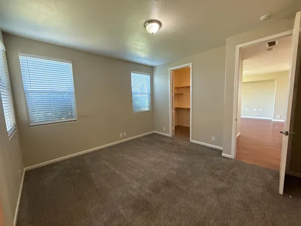 an empty room with windows and closet
