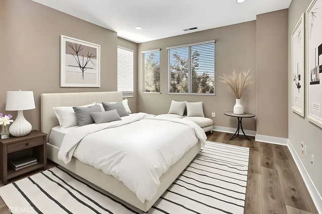 a bedroom with a bed and wooden floor