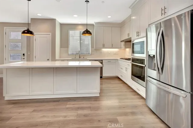 a kitchen with white cabinets stainless steel appliances and a island