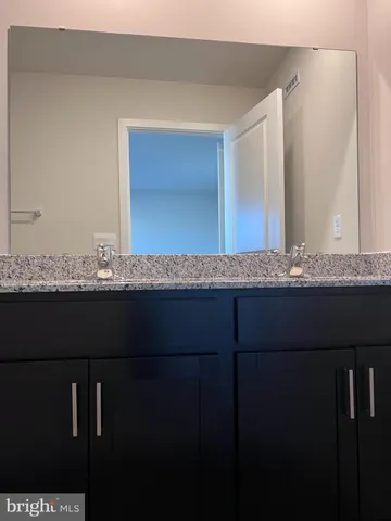 a bathroom with a granite countertop sink and mirror