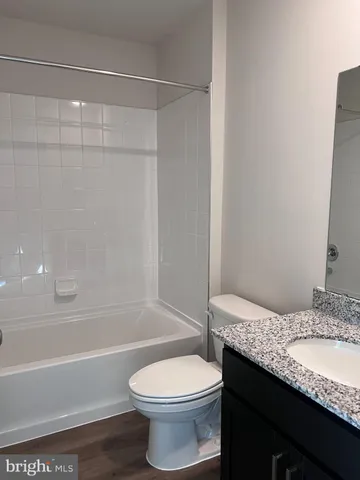 a bathroom with a granite countertop bathtub toilet and a sink