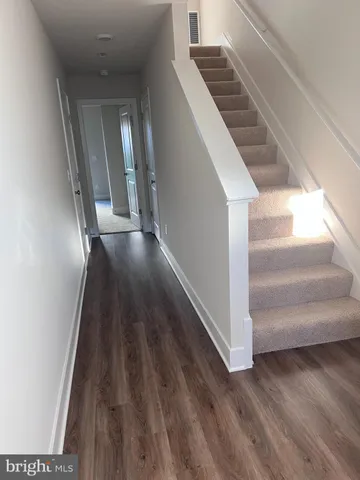 a view of entryway and hall with wooden floor