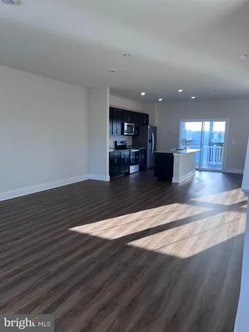 a view of kitchen with cabinets appliances and wooden floor