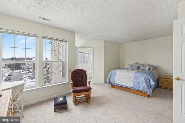 a bedroom with a bed and a large window