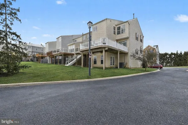 a view of a white house with a big yard and large trees