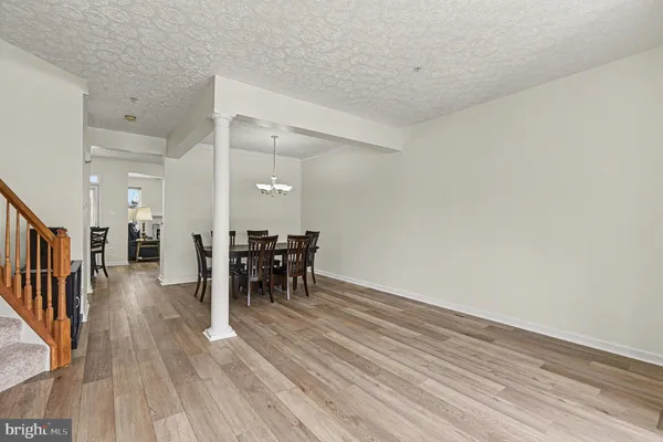a view of a room with wooden floor table and chairs