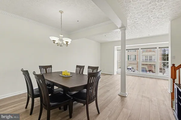 a view of a dining room with furniture a chandelier and wooden floor