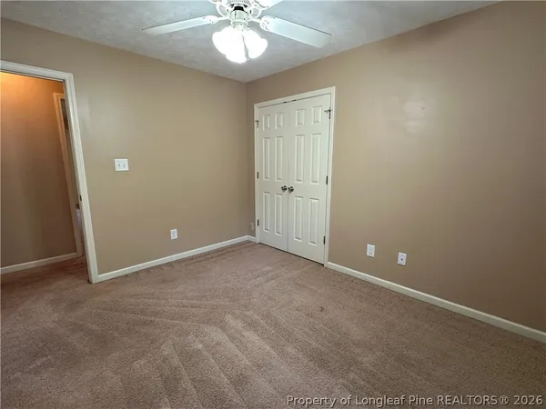 a view of an empty room with a chandelier fan