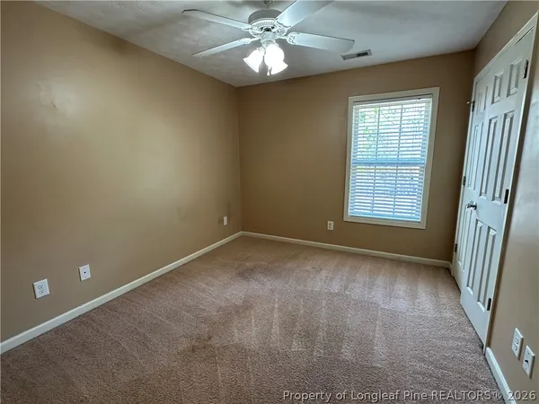 an empty room with a window and a fan