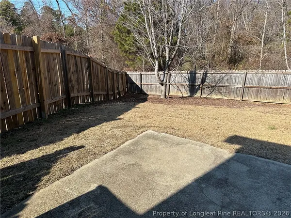 a view of a yard with wooden fence